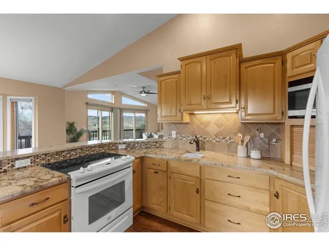 a kitchen with granite countertop a sink stove and cabinets