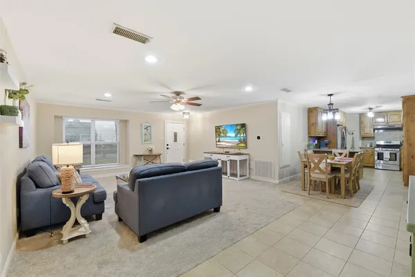 a living room with furniture and a dining table with kitchen view