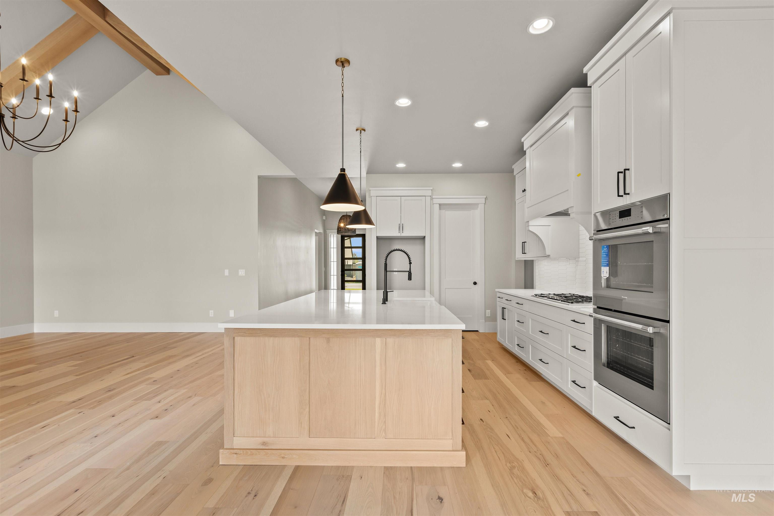 6891 South Utmost Way Meridian, ID 83642 - Photo 18 of 46 Kitchen with light wood-type flooring, a kitchen island with sink, appliances with stainless steel finishes, white cabinetry, and recessed lighting