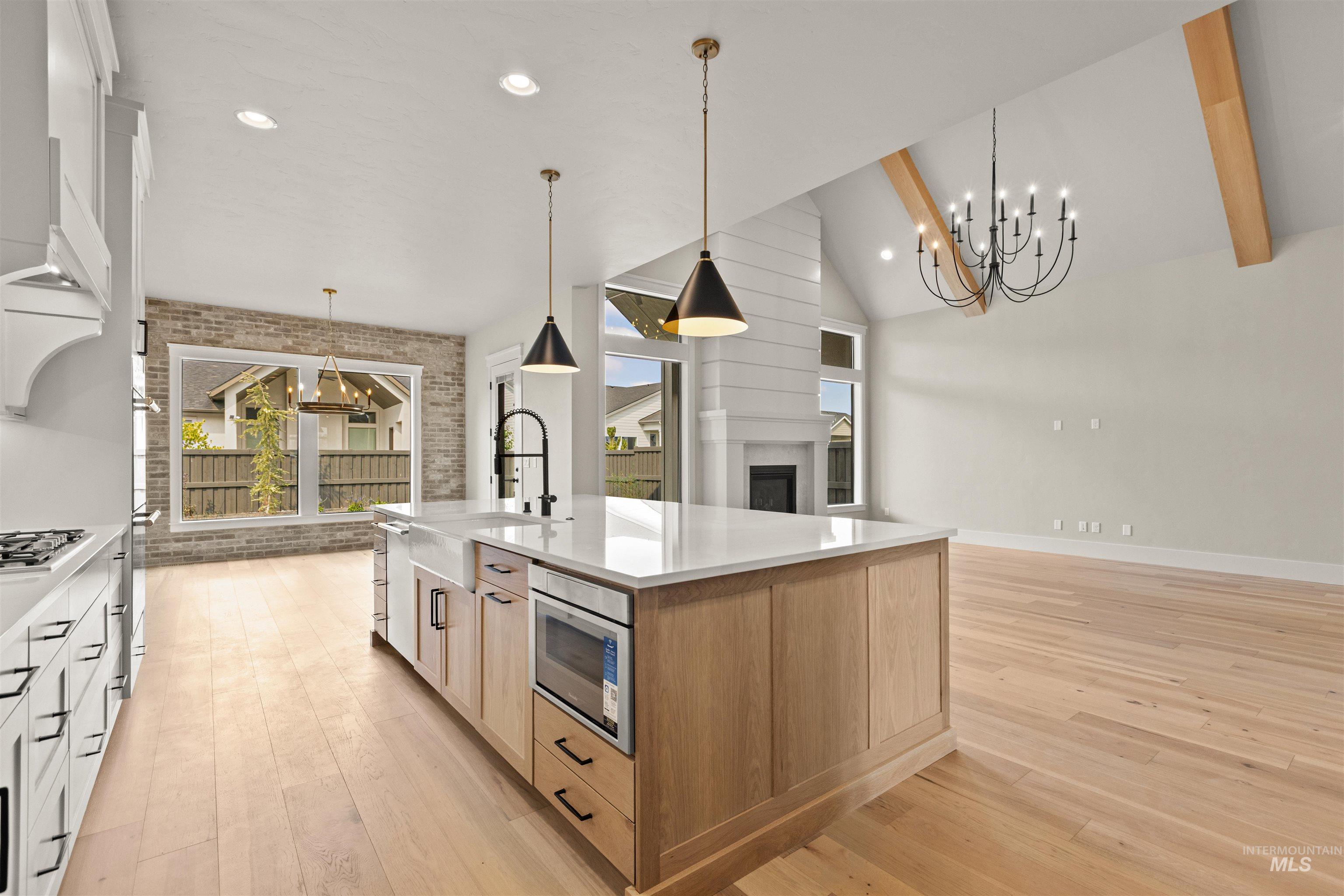 6891 South Utmost Way Meridian, ID 83642 - Photo 22 of 46 Kitchen featuring a chandelier, pendant lighting, recessed lighting, a fireplace, and light wood-type flooring