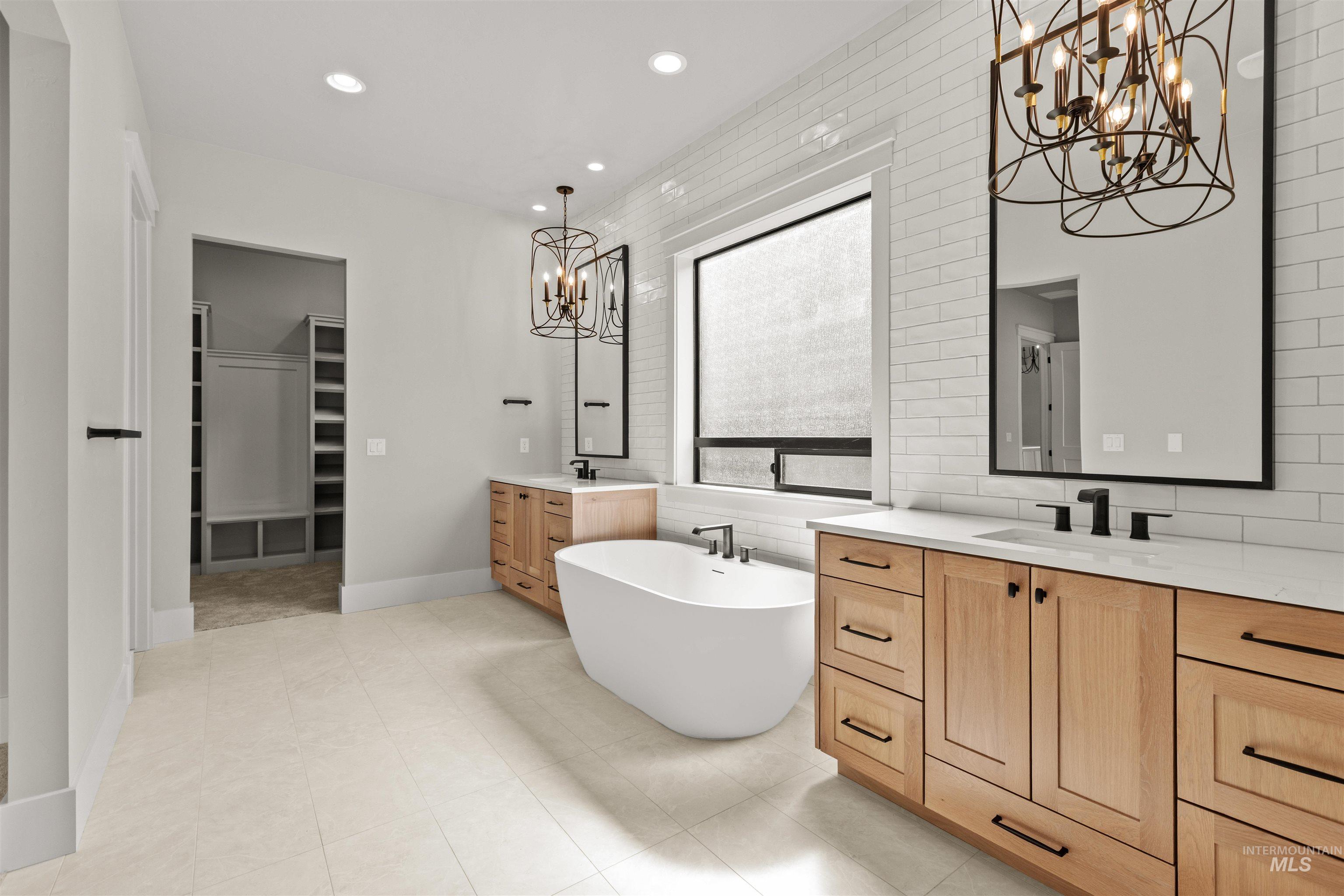 6891 South Utmost Way Meridian, ID 83642 - Photo 30 of 46 Full bath featuring a chandelier, two vanities, a soaking tub, a walk in closet, and recessed lighting