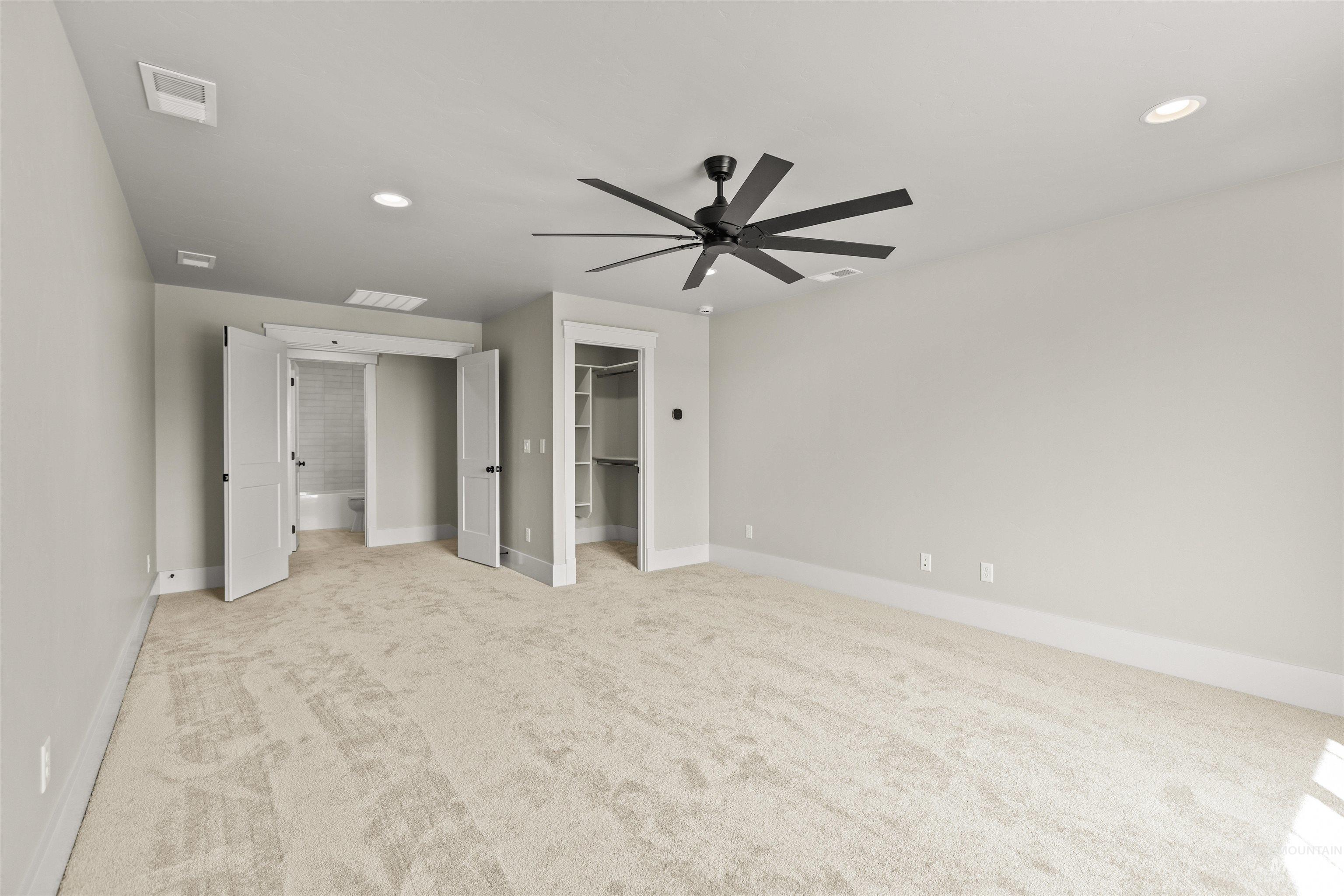 6891 South Utmost Way Meridian, ID 83642 - Photo 39 of 46 Unfurnished bedroom with a spacious closet, light carpet, recessed lighting, and a ceiling fan