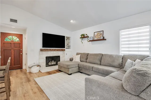 a kitchen with stainless steel appliances granite countertop a stove top oven a sink dishwasher a dining table and chairs with wooden floor