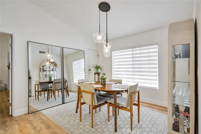 a view of a dining room with furniture a chandelier and wooden floor