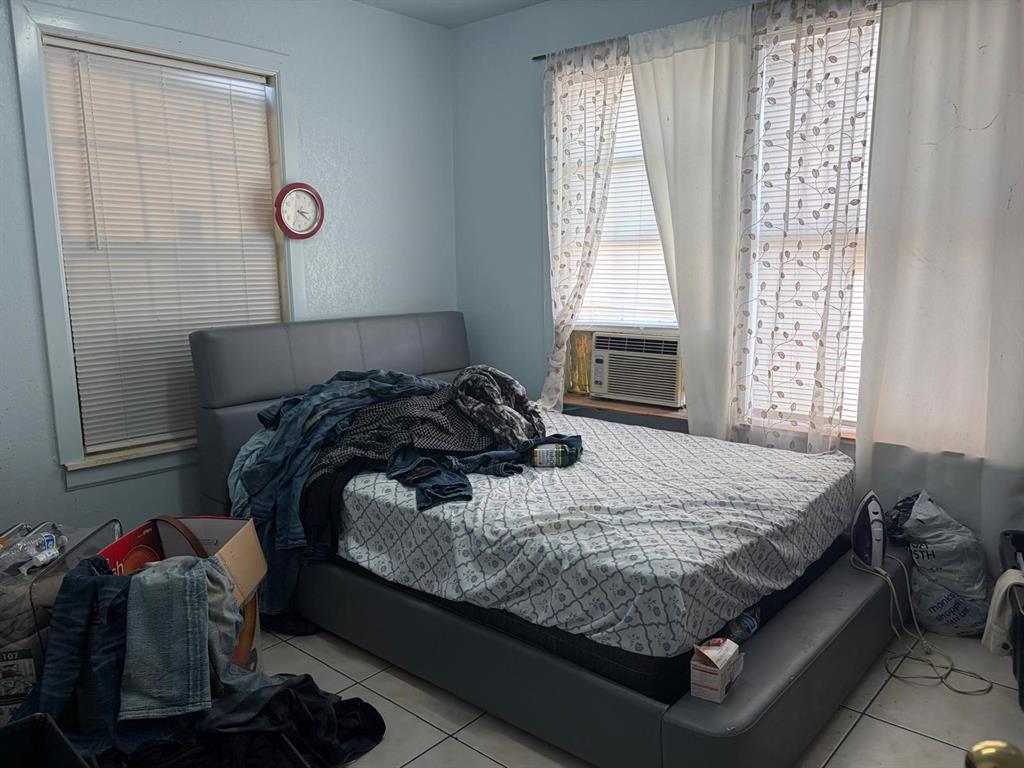 4501 Parrish Road Haltom City, TX 76117 - Photo 12 of 27 a bed sitting in a bedroom next to a window and dresser