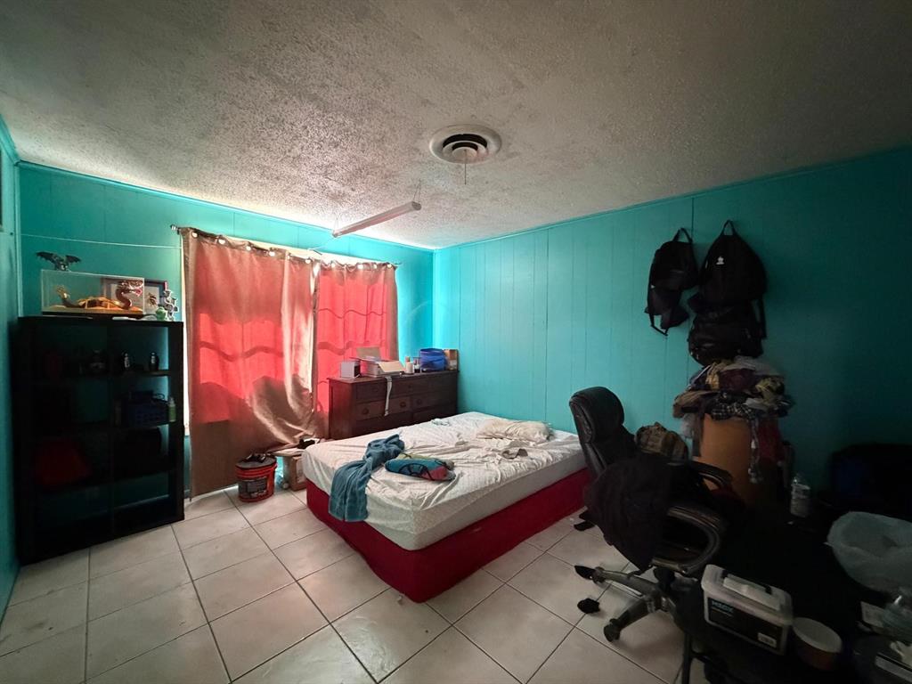 4501 Parrish Road Haltom City, TX 76117 - Photo 25 of 27 a bed room with a bed and a chair