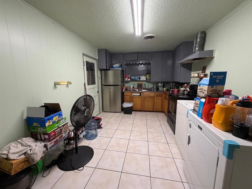4501 Parrish Road Haltom City, TX 76117 - Photo 27 of 27 a kitchen with a refrigerator and a stove top oven