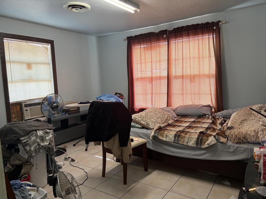 4501 Parrish Road Haltom City, TX 76117 - Photo 6 of 27 a bed sitting in a bedroom next to a window