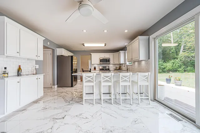 a large kitchen with white cabinets and stainless steel appliances