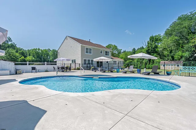 a view of a house with backyard and sitting area