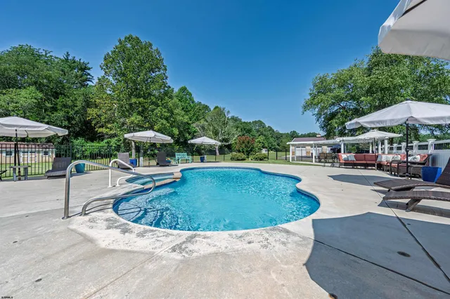 a view of a patio with couches chairs under an umbrella