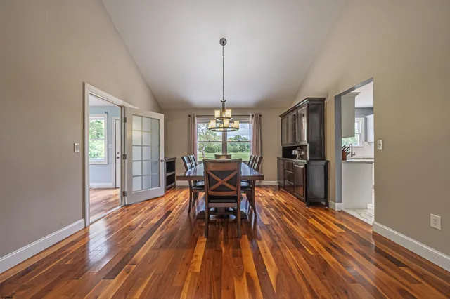 a dining room with furniture window wooden floor and a chandelier