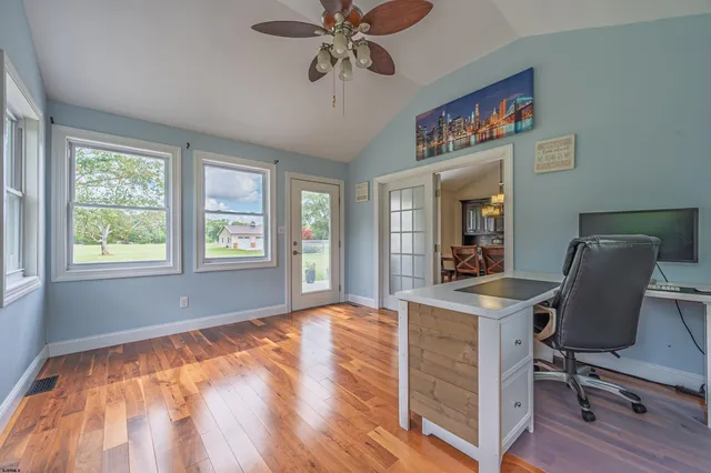 a view of a workspace with furniture and a window
