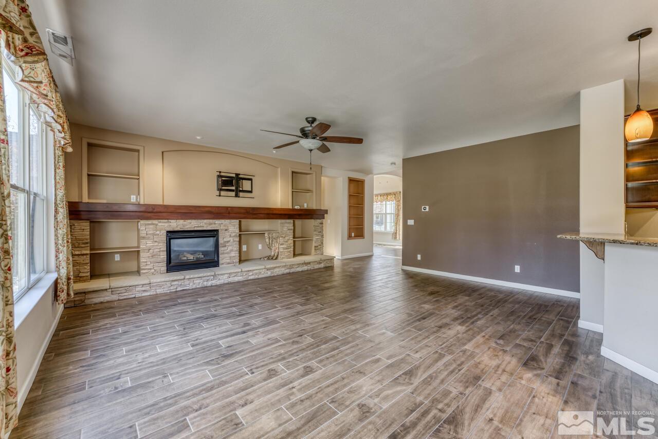 9720 Lemke Court Reno, NV 89521 - Photo 12 of 40 a view of a livingroom with wooden floor a fireplace and window