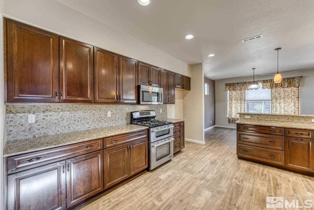 9720 Lemke Court Reno, NV 89521 - Photo 20 of 40 a kitchen with stainless steel appliances granite countertop a stove a sink and a refrigerator