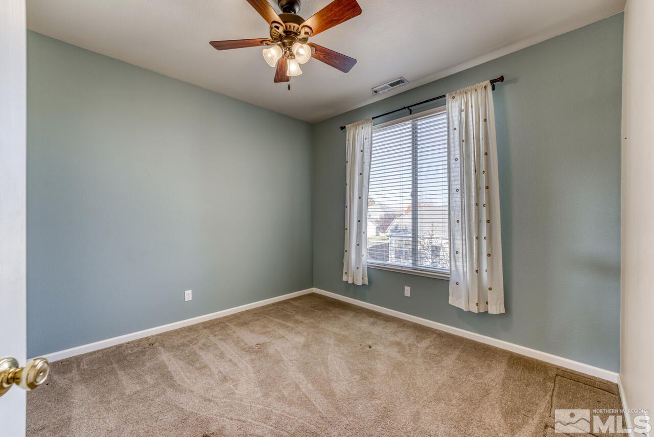 9720 Lemke Court Reno, NV 89521 - Photo 26 of 40 an empty room with chandelier fan and windows