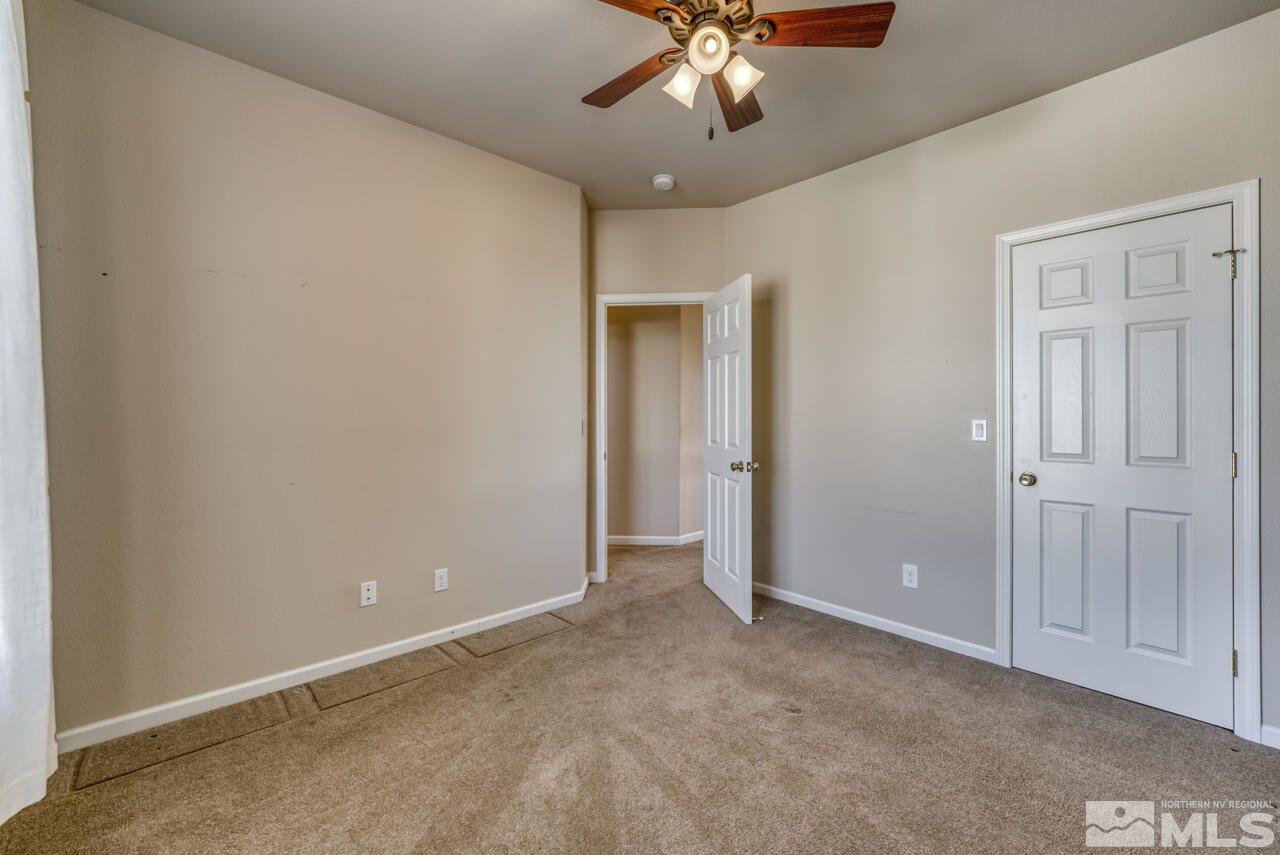 9720 Lemke Court Reno, NV 89521 - Photo 27 of 40 a view of an empty room with a chandelier fan