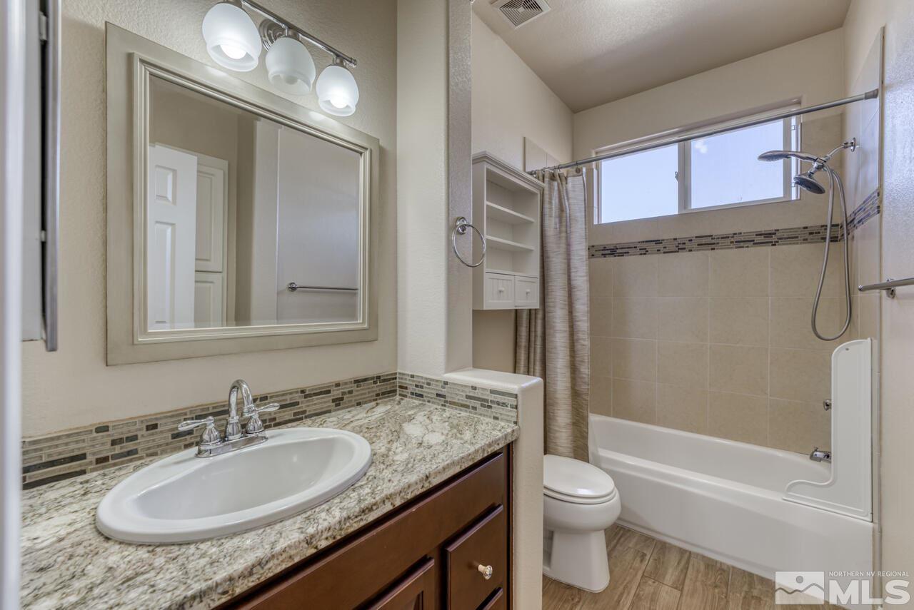 9720 Lemke Court Reno, NV 89521 - Photo 30 of 40 a bathroom with a granite countertop sink toilet and shower