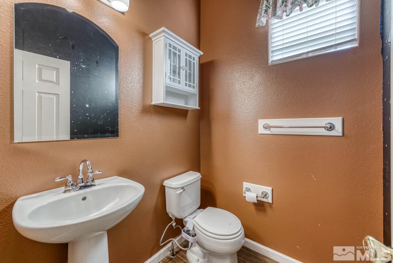 9720 Lemke Court Reno, NV 89521 - Photo 31 of 40 a bathroom with a sink a toilet and mirror