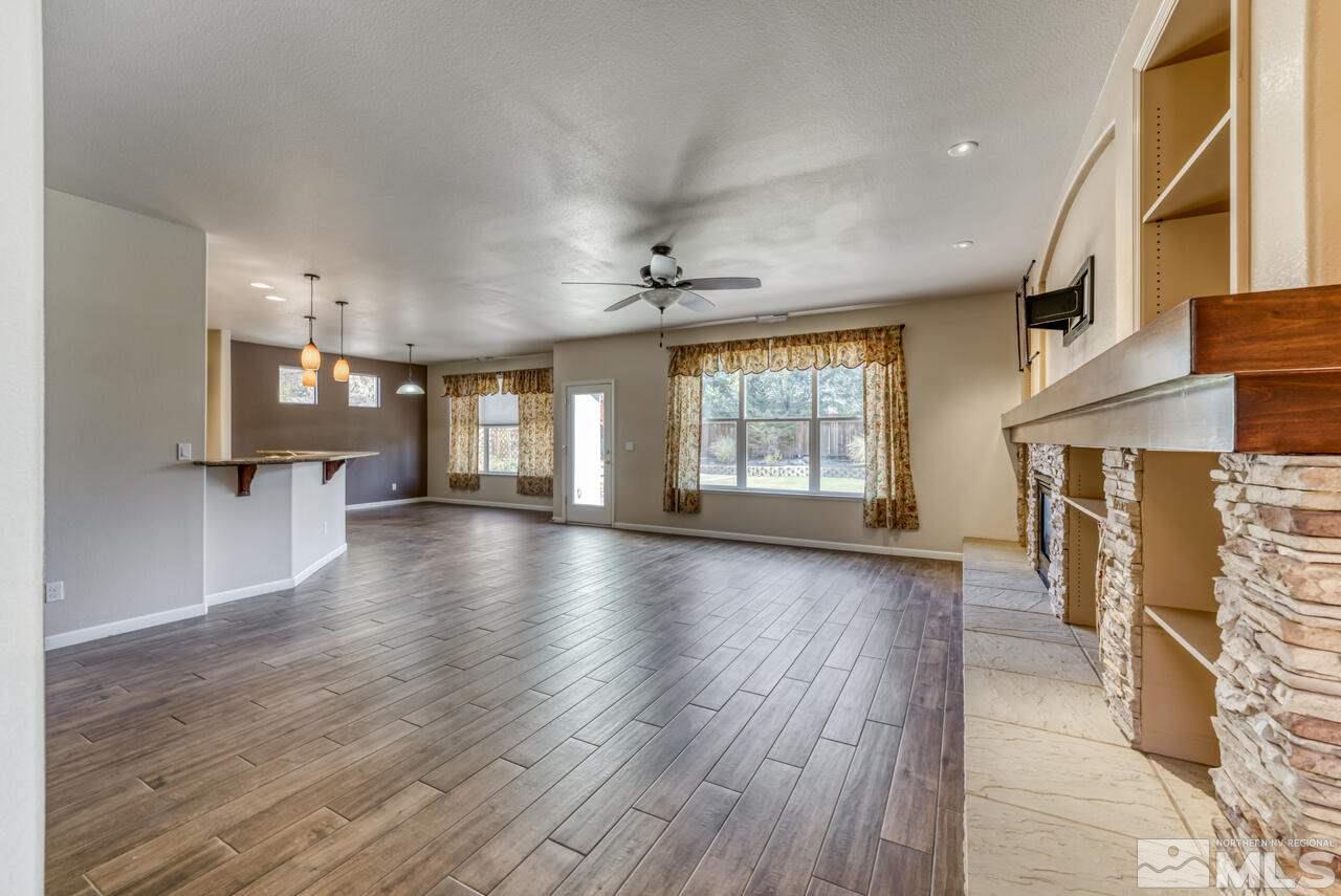 9720 Lemke Court Reno, NV 89521 - Photo 9 of 40 an empty room with wooden floor and a fireplace
