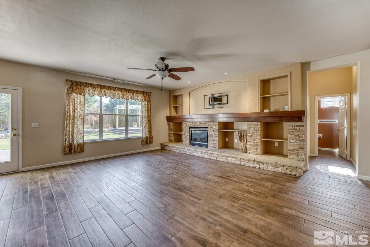 9720 Lemke Court Reno, NV 89521 - Photo 10 of 40 an empty room with wooden floor and a kitchen