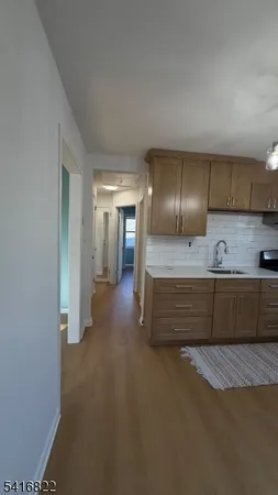 an empty room with chandelier fan and windows