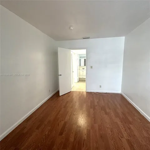 a view of an empty room and wooden floor