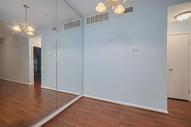 a view of a chandelier in big room with wooden floor