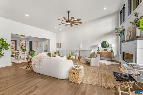 a living room with furniture kitchen view and a chandelier
