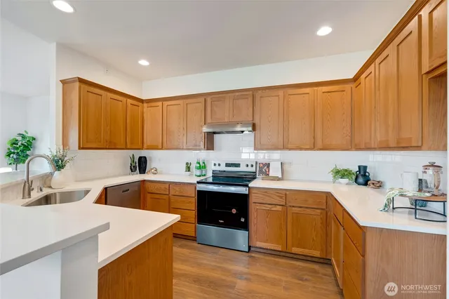 a kitchen with a sink white cabinets and white appliances