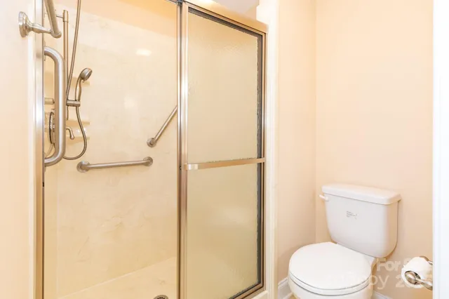 a white toilet sitting next to a shower