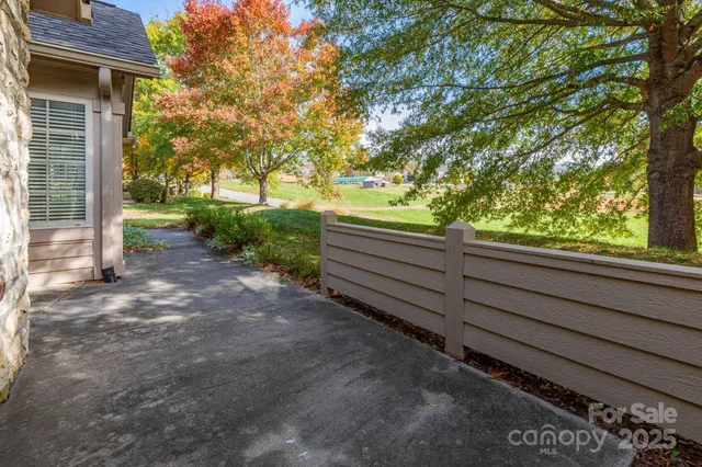 a view of a yard with wooden fence