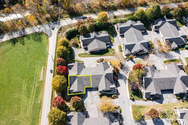 an aerial view of residential houses with outdoor space and parking