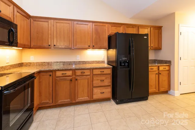 a kitchen with stainless steel appliances granite countertop a refrigerator and a sink