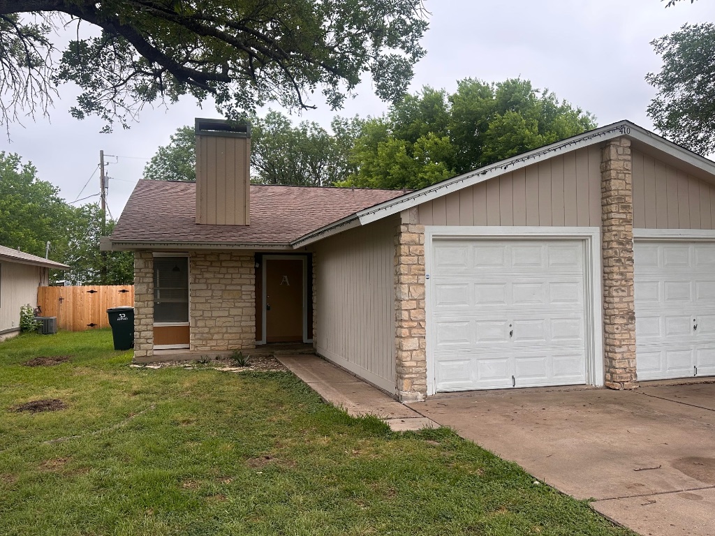 410 Linden Street, Unit A Bastrop, TX 78602 - Photo 1 of 17 a front view of a house with a garden