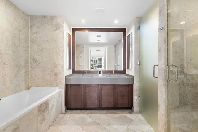 a bathroom with a granite countertop sink a toilet a mirror and bathtub