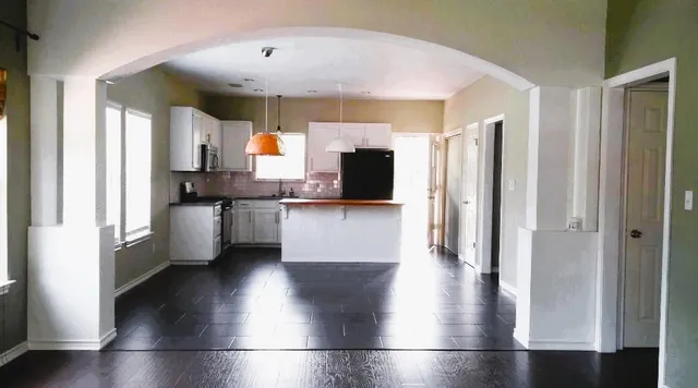 a view of a kitchen with a sink a refrigerator and window