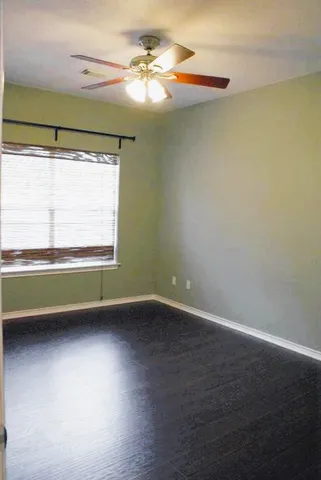 an empty room with wooden floor and a window