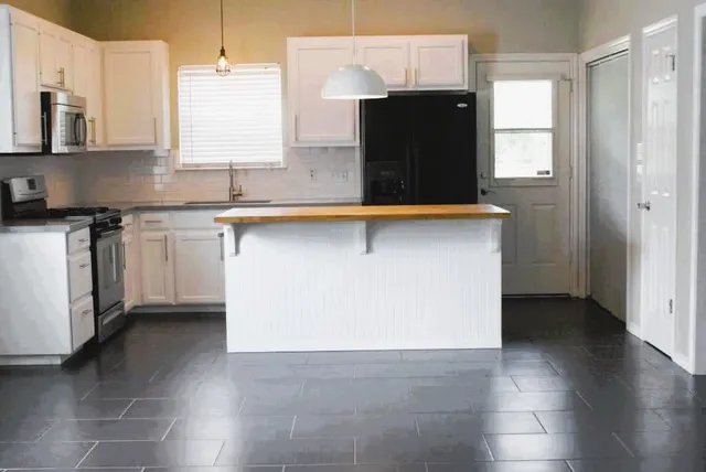 a kitchen with stainless steel appliances granite countertop a refrigerator and a sink