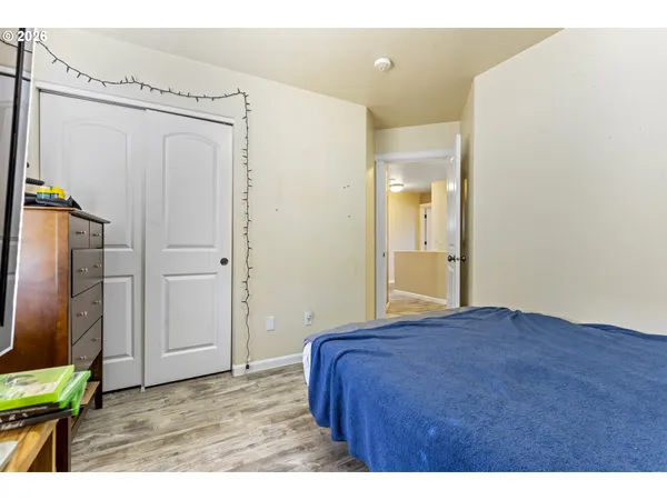 a bedroom with a bed and a flat tv screen on dresser