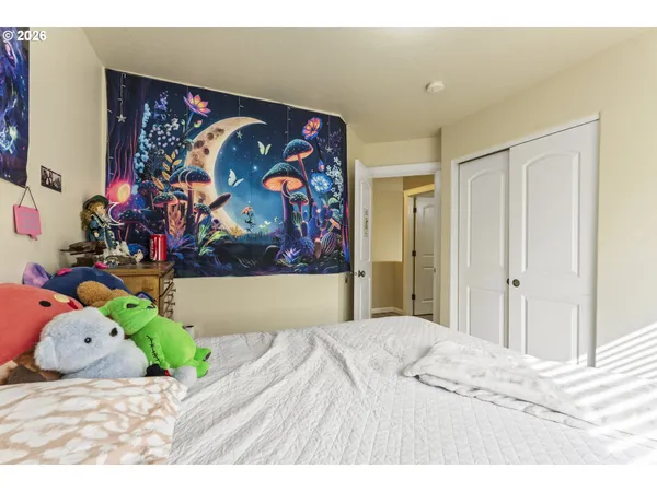 a bedroom with a bed and painting on the wall