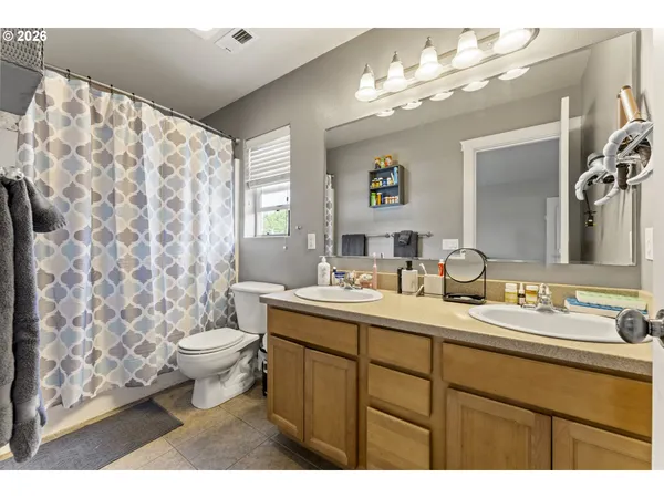 a bathroom with a toilet sink double vanity and mirror