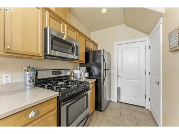 a kitchen with stainless steel appliances a stove a microwave a sink and cabinets