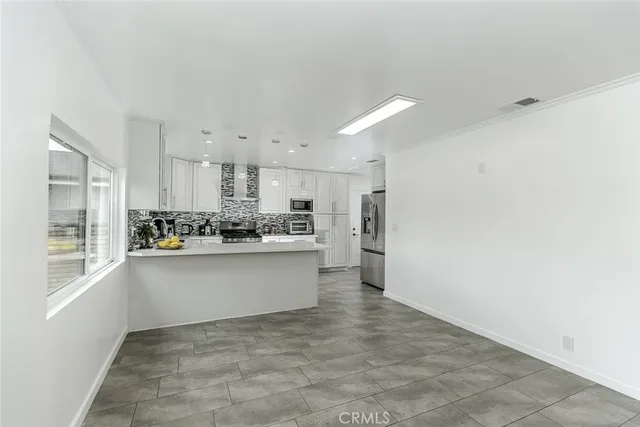 a kitchen with stainless steel appliances a stove a sink and a microwave