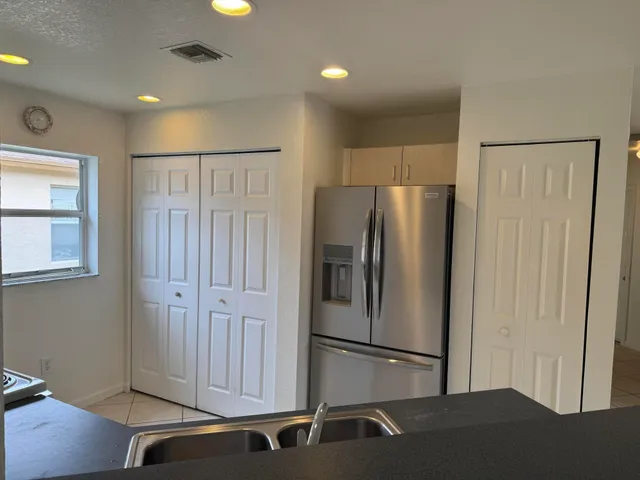 a metallic refrigerator freezer sitting in a kitchen