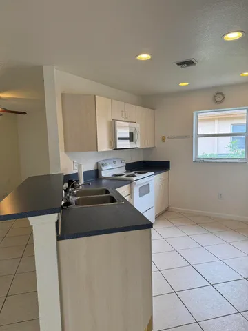 a kitchen with granite countertop a sink a stove and cabinets