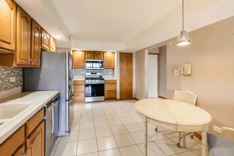 a kitchen with stainless steel appliances granite countertop a sink and a refrigerator