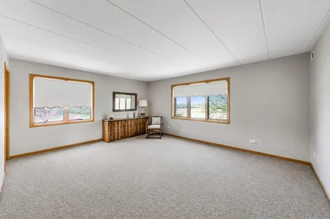 an empty room with windows cabinet and fireplace