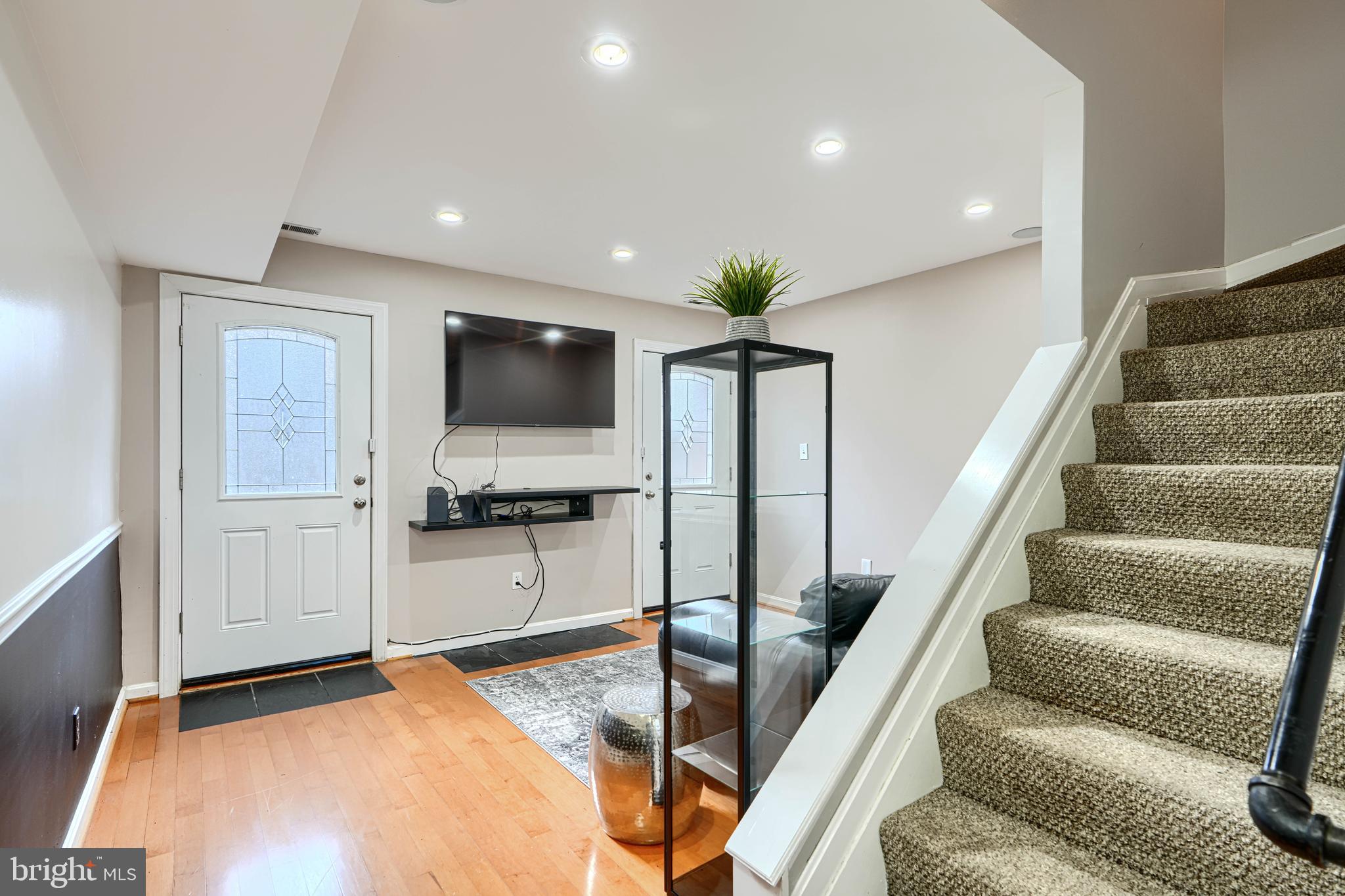 624 Jasper Street Baltimore, MD 21201 - Photo 12 of 24 a view of a livingroom with furniture a flat screen tv and staircase