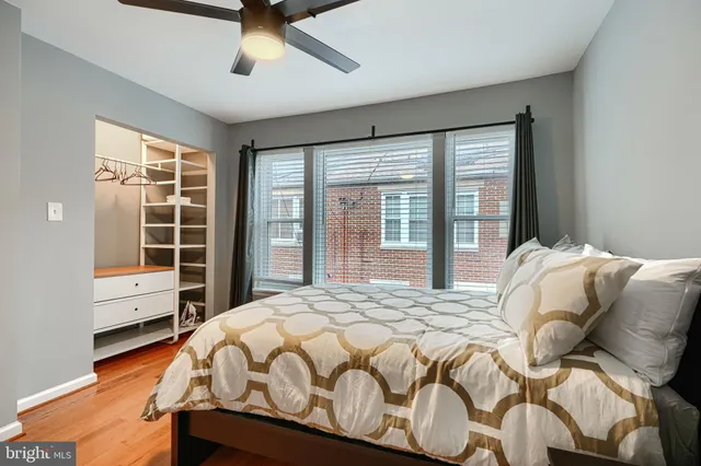 a bedroom with a bed a washer and dryer next to a window